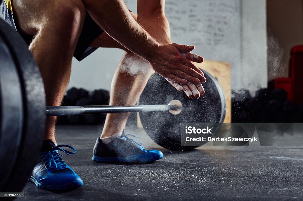 Closeup of weightlifter clapping hands before  barbell workout a Closeup of weightlifter clapping hands before  barbell workout at the gym Weightlifting Stock Photo