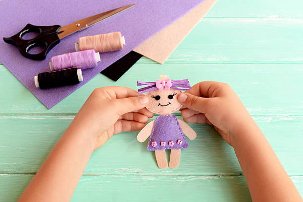 istock Child holds felt doll in hands and shows it 601905754