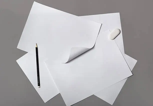 Stack of paper with pencil on gray background
