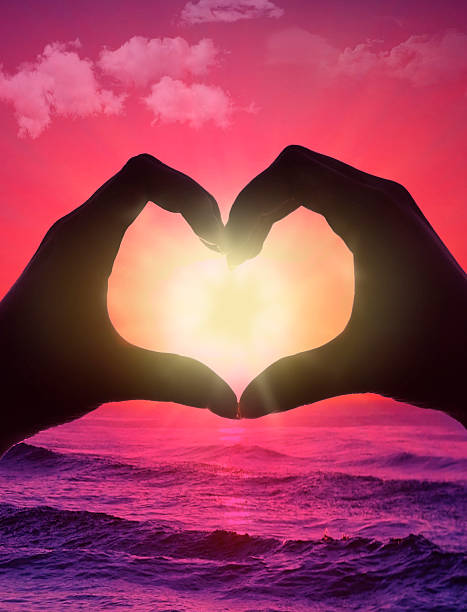 istock Hands of Heart shape with sea and sky sunset 601910396