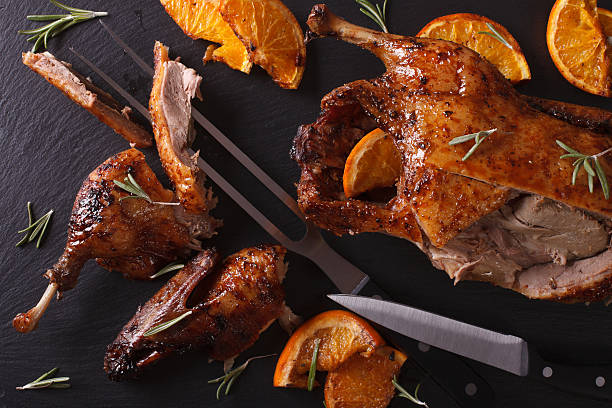 istock Cutting the roast duck and oranges closeup. Horizontal top view 601911288