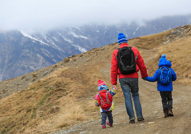 istock father with two kids hiking in winter mountains 601912064