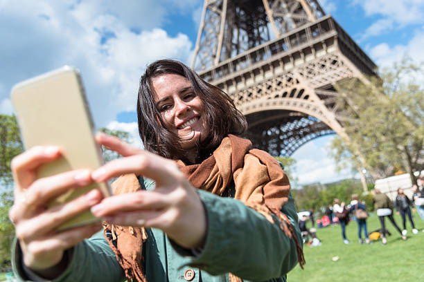 istock woman self photographing on paris ith the tour eiffel 601912644