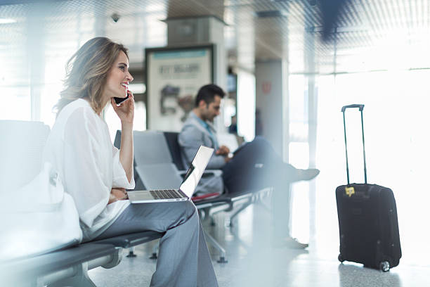 работа и использование телефона во время ожидания на выходе на посадку. - airport women waiting business travel стоковые фото и изображения