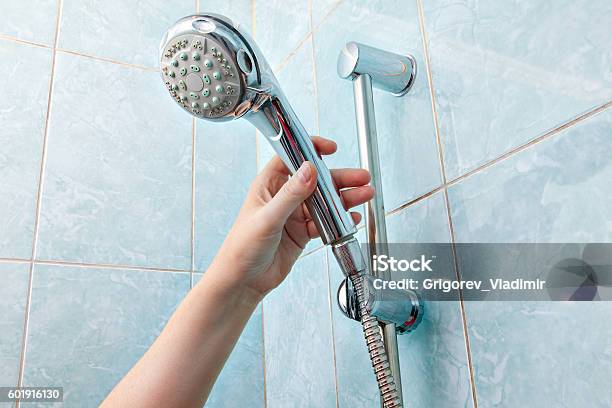 Closeup Of Human Hand Adjusts Holder Shower Head With Hose Stock Photo - Download Image Now
