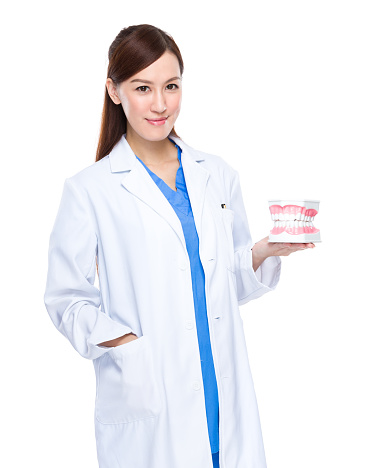 Female dentist holding dentures