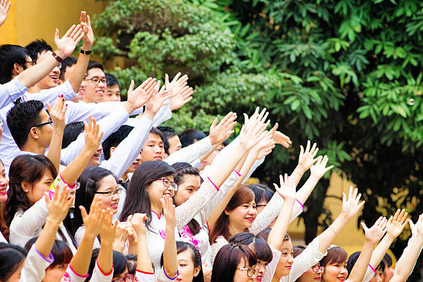 Hanoi, Vietnam - April 18, 2015: Vietnamese students with hands up to celebrate graduation. Photographed in Hanoi, Vietnam.