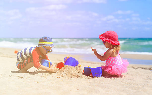 istock kids play with sand on summer beach 601919530