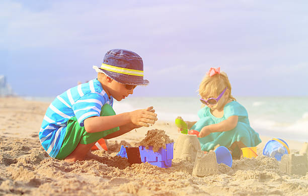 istock kids play with sand on summer beach 601921104