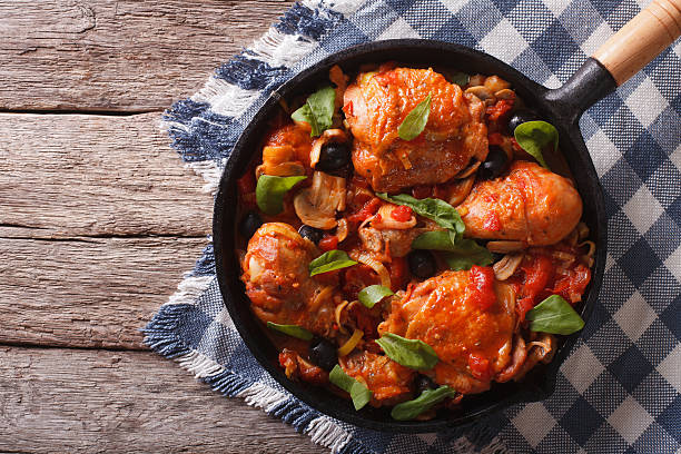 Cacciatori Chicken with mushrooms in a pan. horizontal top view