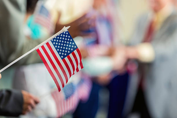 istock People waving American flags in support at political campaign rally 601923376