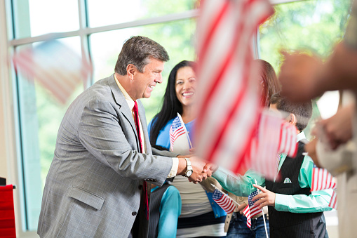 Businessmen shaking hands in front of a USA flag