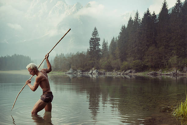 Fisherman Barbarian man fishing in the lake spear stock pictures, royalty-free photos & images