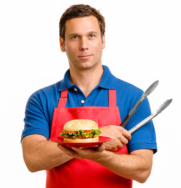 istock Man with Hamburger and Barbeque Tongs on White 601924522