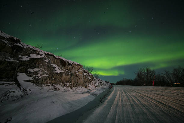 istock Northern light (aurora borealis) over an icy snowy road 601925084