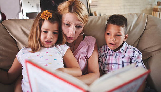 istock mother with kids  reading a book at home 601925544