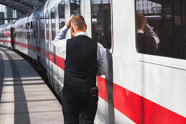 Train conductor from behind standing at station Berlin, Germany - September 9, 2016: Train conductor from behind standing in front of ice train at central station in Berlin. deutsche bahn stock pictures, royalty-free photos & images