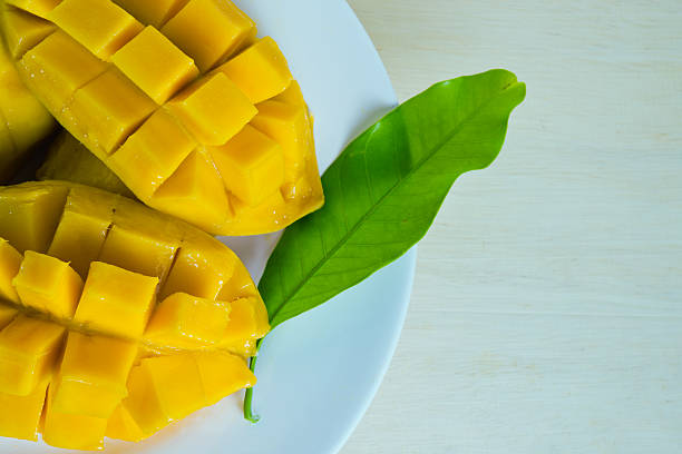 istock Mango nicely cut with leaf on wooden background (Also known 601928318