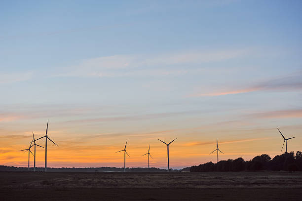Silhouette of wind turbine on sunset stock photo