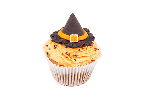 Halloween cupcake with colored decorations Halloween cupcake with witch hat decorations made from confectionery mastic, isolated halloween cupcake stock pictures, royalty-free photos & images