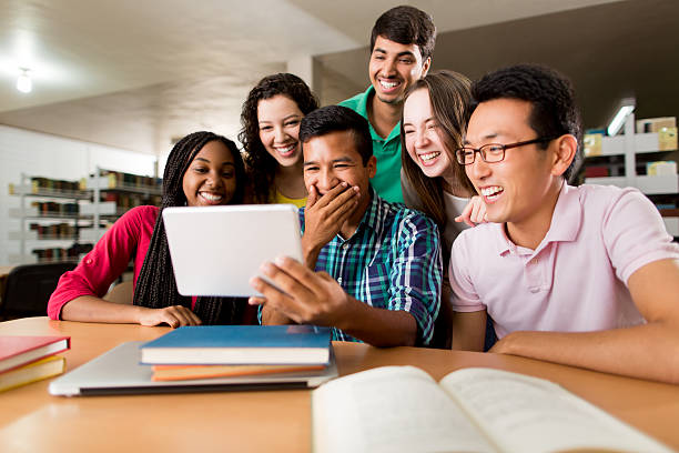 multiethnische gruppe lacht mit digitalem tablet - computer student mixed race person multi ethnic group stock-fotos und bilder