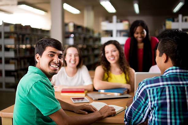 istock Nepalese student sitting with friends and smiling at camera 601934960