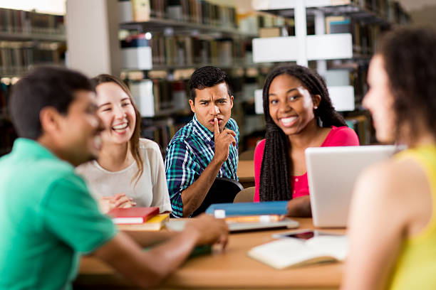 istock Student making silence sign to other students in library 601935358