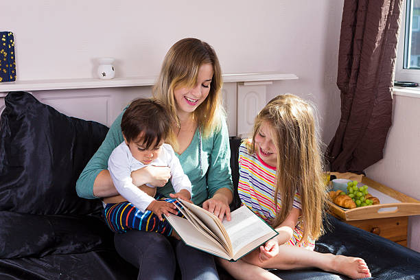 istock Mother reading to kids in bed 601935856