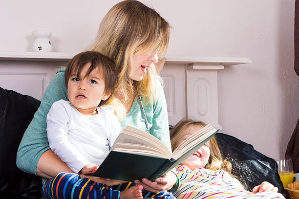 istock Mother reading to kids in bed 601936008