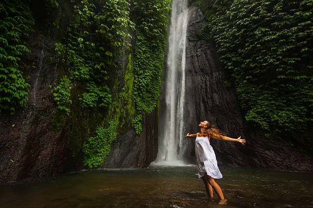 istock woman meditating doing yoga between waterfalls 601940410