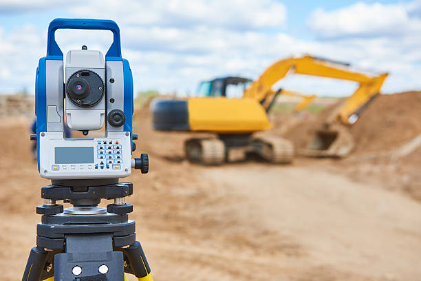 istock surveyor equipment theodolie at construction site with excavator 601940918