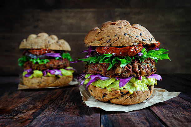 Homemade veggie burger Fresh beetroot lentil vegan burger with grilled eggplant, sun-dried tomatoes and guacamole sauce veggie burger photos stock pictures, royalty-free photos & images