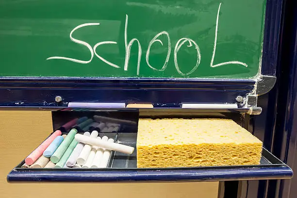 there is color chalk and sponge on the blackboard