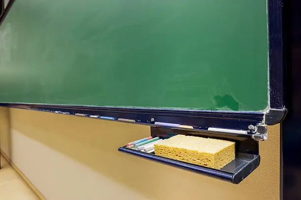 there is color chalk and sponge on the blackboard