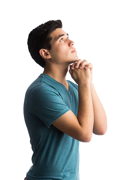 istock Young latin man praying with eyes open 601941922