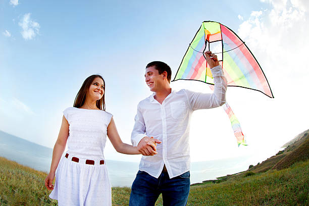 istock Happy young couple in love with flying a kite 601944606