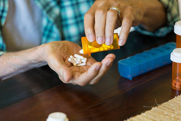 istock Senior man pours medication into his hand 601946882