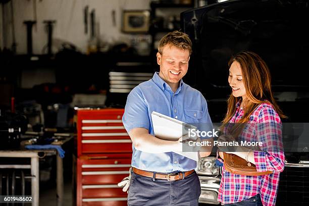 Happy Customer Discusses Repairs With Auto Mechanic In Repair Shop Stock Photo - Download Image Now