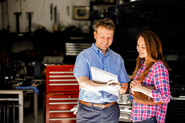 happy customer discusses repairs with auto mechanic in repair shop. - repairing auto repair shop service technician imagens e fotografias de stock