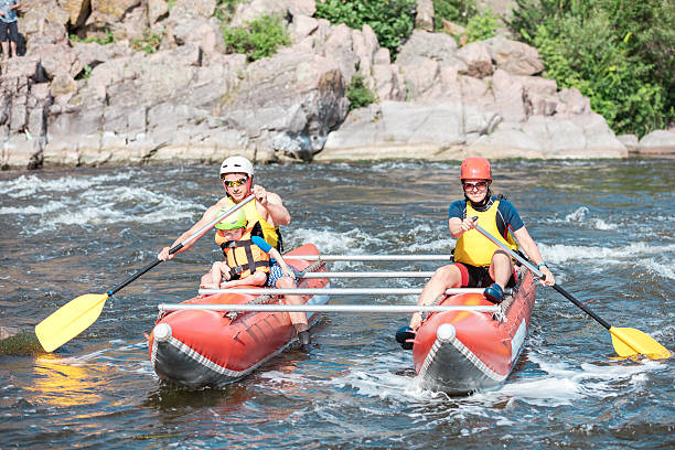 istock Young couple with a little son rowing up the stream 602290248