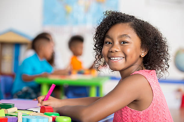 istock Smiling girl colors in her art class 602290574