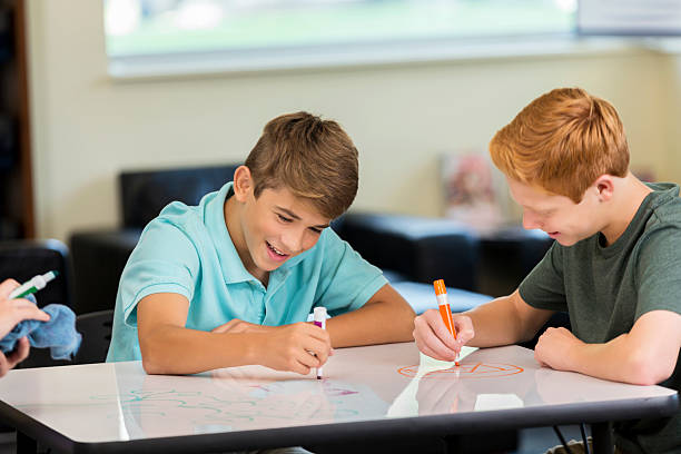istock Happy male high school students working together on art project 602290624