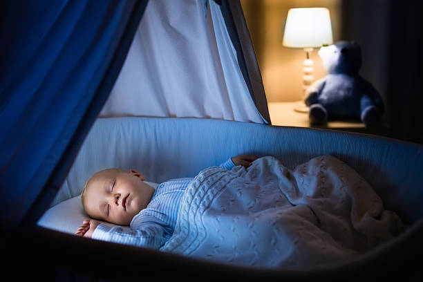 istock Baby boy sleeping in blue crib at night 602291002