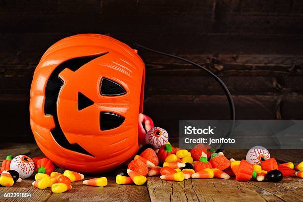 Spilling Halloween Jack O Lantern Candy Pail On Wood Stock Photo - Download Image Now