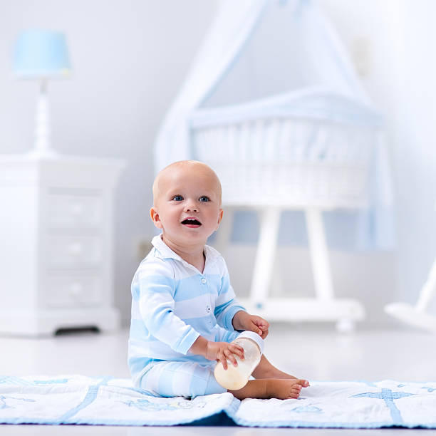 istock Baby boy drinking milk in sunny nursery 602291864