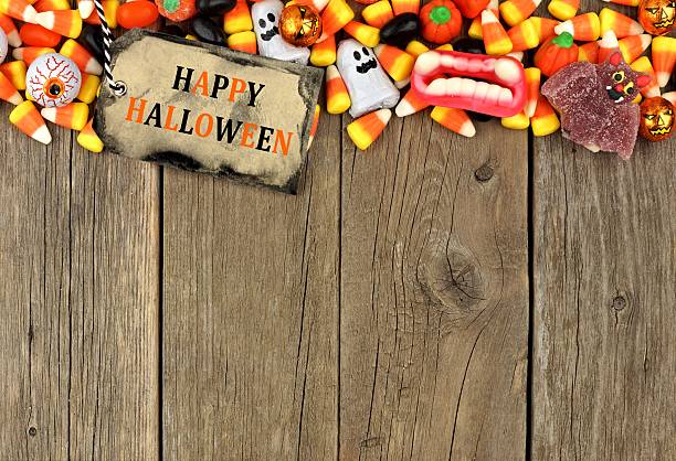 istock Happy Halloween tag with candy top border over rustic wood 602292720