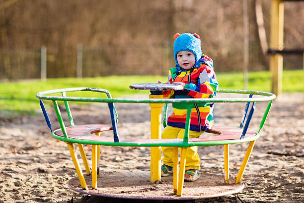 istock Little boy on playground on a swing in autumn 602294332