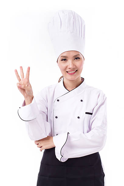 istock happy, smiling, positive female chef pointing up four fingers 602297508