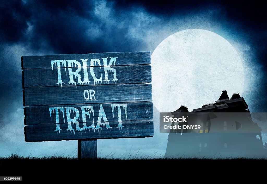Trick Or Treat Sign in Front Of Haunted House An old and weathered sign that has "Trick or Treat" painted on it as it stands in a grassy field as a full moon rises behind a haunted house. Full Moon Stock Photo
