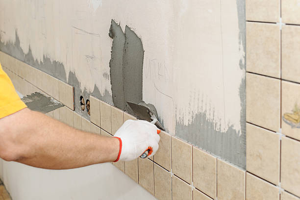 istock Worker instiling tiles on the wall in the kitchen. 602301196